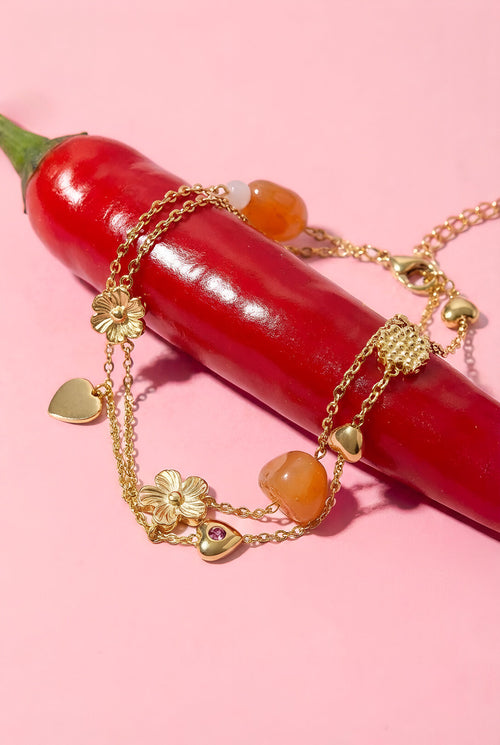 Bedelarmband met oranje kralen, bloemen en hartjes